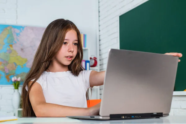 Wesoły dzieciak dziewczyna z komputera na lekcjach szkolnych, e-learning — Zdjęcie stockowe