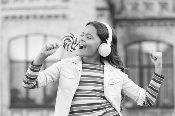 Feliz belleza cantando en caramelos. niño innovando educación. Feliz día de los niños. estilo de vida saludable. colegiala con piruleta. niño feliz con auriculares. alumno escuchar música y cantar canción. de vuelta a la escuela — Foto de Stock