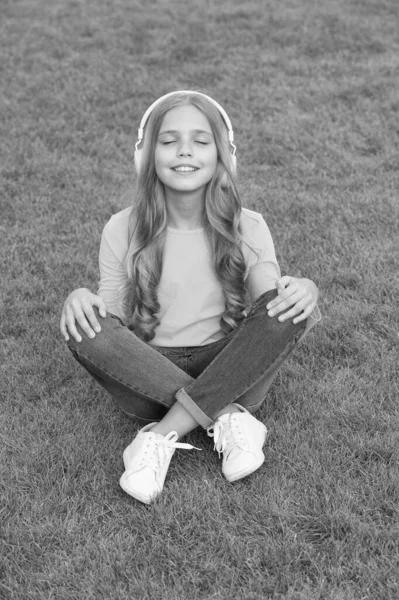 Schattig lachend meisje moderne hoofdtelefoon genieten van muziek ontspannen buiten, feel tune concept — Stockfoto