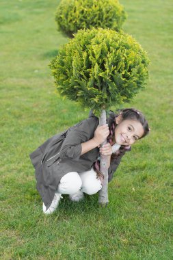 Küçük kız için bahar modası. thuja 'dan mutlu çocuk. Doğa tasarımı. Parklar ve açık hava. Sonbahar havası. Selvi ağacı. Moda saç stili olan küçük bir kız. Merhaba bahar. Mutlu sonbahar günleri.