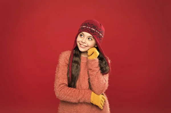 Pidiendo deseos navideños. Traje de invierno. Un niño pequeño usa un sombrero de punto. Mantente caliente. Pequeña niña accesorio de moda de invierno. Niño pequeño pelo largo usar sombrero fondo borgoña. Lindo modelo disfrutar del estilo de invierno — Foto de Stock