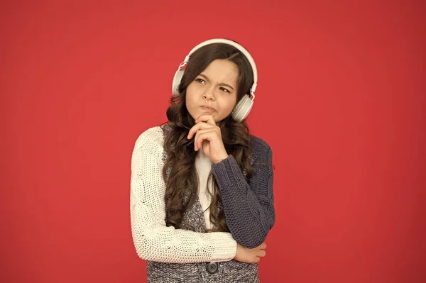 Home education. Happy girl listen music red background. Listening to melody and thinking. study online with audio book. Little girl listen to song in headphones. New technology. Technology and music — Stock Photo, Image