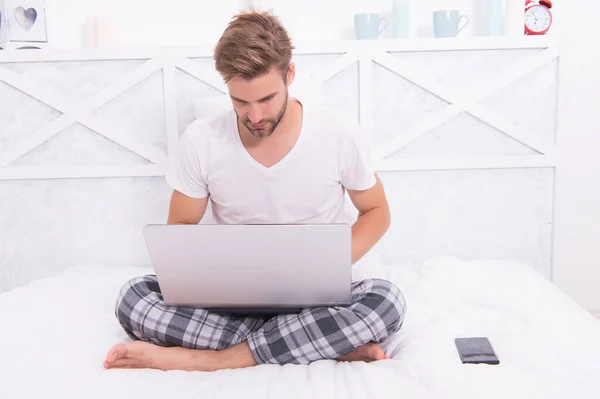 Jobba hemifrån. Ung kille jobbar på laptop i sängen. Krisen med Coronavirus COVID-19 — Stockfoto