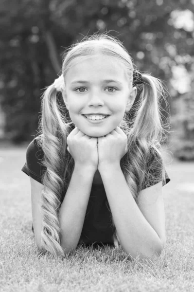 Petite fille mignonne queue de cheval coiffure relaxante sur herbe verte, concept de camp d'été — Photo