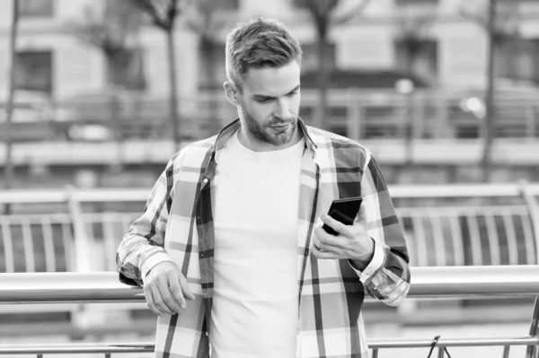 A tua verdadeira companheira. Bonito homem usar telefone ao ar livre. Conversa online. Mensagem SMS. Mensagens de telemóvel. Telemóvel. Smartphone. Telefone portátil. Nova tecnologia. Vida moderna — Fotografia de Stock