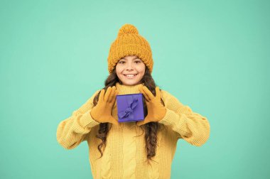 İyi bir hediye için minnettar hissediyorum. Kış tatili Mutlu noeller. Çocuk mutlu bir hediye kutusu. Küçük kız sıcak şapka takıyor. Beklenmedik bir sürpriz. Doğum gününü kutlayalım. Çocuk doğum günü hediyesini seviyor.