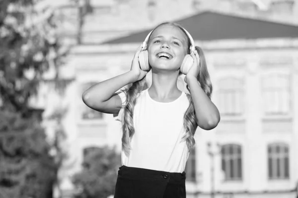 Müzik dinleyen aktif bir kız. Yürürken modern kablosuz kulaklık. Yetenekli şarkıcı konsepti. — Stok fotoğraf