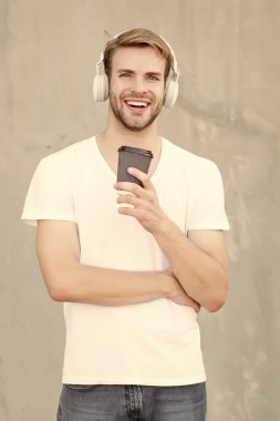 Yerel kahve dükkanlarını destekleyin. Yakışıklı adam kağıt bardak yapmak için kahve içer. Kafe konsepti. Kahve dükkanı. Adam taze demlenmiş kahveyi seviyor. Mükemmel latte. Günlük kafein miktarı. Müzikle yürüyorum