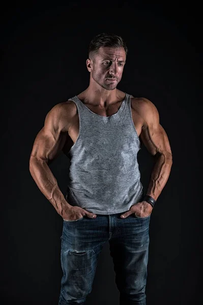 Var stark. Stark man i avslappnad stil svart bakgrund. Bygga biceps och triceps. Muskelträning. Sport och fitness. Kroppsvård och välbefinnande. Hälsa och diet. Bli starkare — Stockfoto