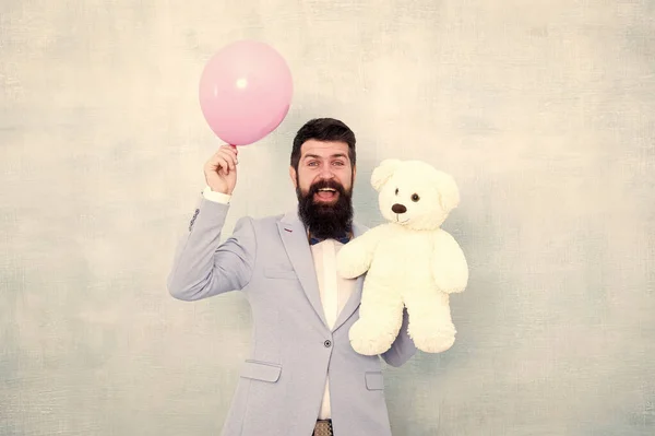 Presente do dia dos namorados. Feliz aniversário. ir para compras de presente. brutal hipster barbudo em desgaste formal. homem de negócios segurar urso brinquedo e balão. smoking homem pronto para encontro romântico. Amor e romance — Fotografia de Stock