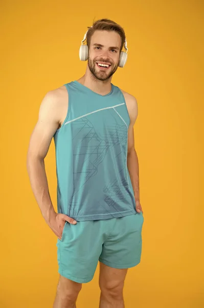 Müzik kulaklığı dinleyen yakışıklı, traşsız bir sporcu. Spor müzikle daha iyidir. Favori şarkı listesiyle antrenman yapmak rahat. Spor olsun diye kablosuz kulaklık. Modern kulaklık konsepti — Stok fotoğraf