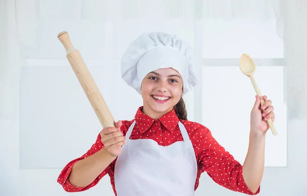 Fille enfant heureux dans chapeau de cuisinier et tablier dans la cuisine, chef — Photo