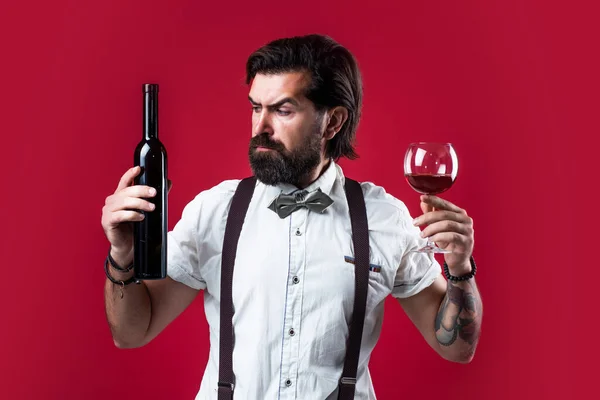 I offet this. bearded man in suspenders drink red wine. elegant businessman wear bow tie for formal event. sommelier tasting alcohol. bartender. stylish male barman. drinking wine glass — Stock Photo, Image