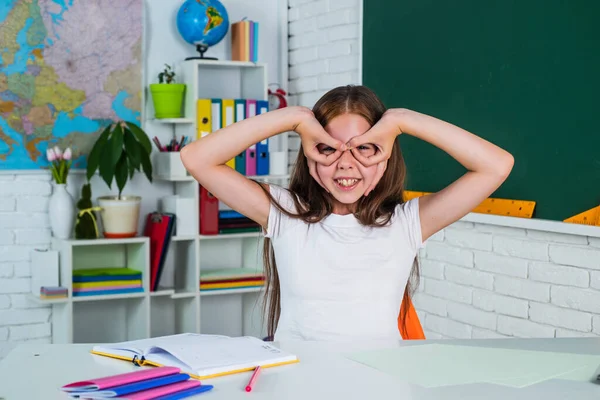 Usmívající se teen dívka dělat obličeje ve škole třídě, baví — Stock fotografie