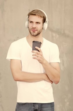 Müzikle yürümek. Yerel kahve dükkanlarını destekleyin. Yakışıklı adam kağıt bardak yapmak için kahve içer. Kafe konsepti. Kahve dükkanı. Adam taze demlenmiş kahveyi seviyor. Mükemmel latte. Günlük kafein miktarı