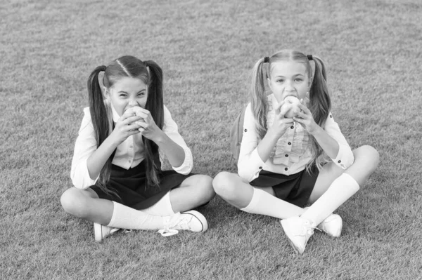 Alunas comendo maçãs relaxante pátio da escola, conceito de almoço saudável — Fotografia de Stock