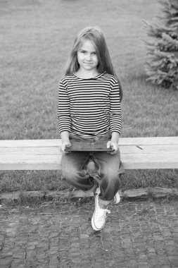 Cep telefonu ve tablet internet kullanımı. Küçük çocuk park bankında otururken tablet kullanıyor. Cep telefonu kişisel bilgisayarı. Cep telefonu şebekesi. Taşınabilir ve mobil cihaz. Yeni teknoloji. Modern hayat. 3G mi? 4G