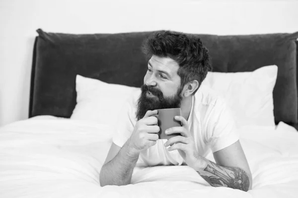 男人快乐的胡子脸喝早茶放松在卧室，咖啡因用量的概念 — 图库照片