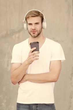 Müzik titreşimleriyle. Modern adam müzik dinleyerek kahve içer. Gençler için modern teknoloji. Paket servis içkisi. Modern müzik. Modern hayat. Aktif yaşam tarzı. Sıradan tarz ve moda.