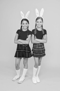 Uzun tavşan kulaklı liseli kızlar üniforması. Geleneksel Paskalya oyunları. Tavşan takımı. Eğlence ve olay konsepti. Bahar tatili. Tavşan kulaklı çocuklar. Aile ve kardeşlik