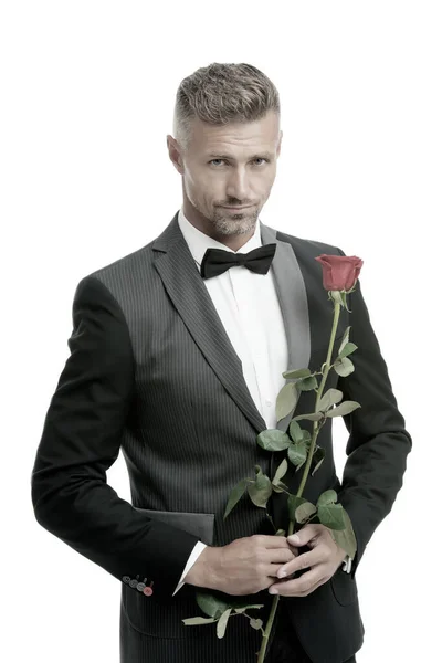 Κάνε καλή πρώτη εντύπωση. Ημέρα του Αγίου Βαλεντίνου και επέτειος. Ρομαντικός κύριος. Άνδρας ώριμη αυτοπεποίθηση macho με ρομαντικό δώρο. Όμορφος τύπος τριαντάφυλλο ρομαντικό ραντεβού λουλούδι. Καλοφτιαγμένο αντρικό κοστούμι. — Φωτογραφία Αρχείου