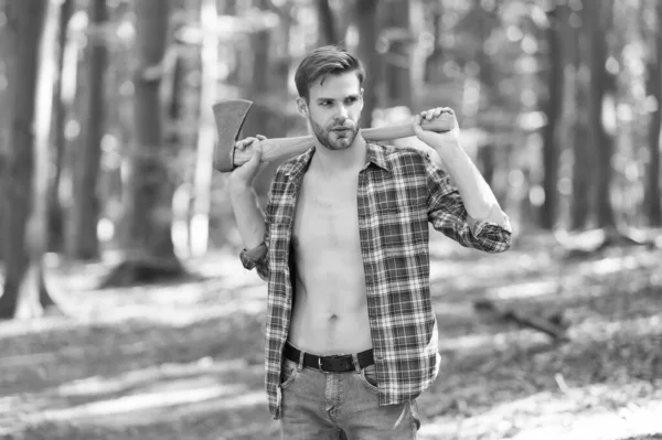 Fit handsome guy with sexy torso in open plaid shirt hold large axe in muscular hands summer wood, strong — Stock Photo, Image