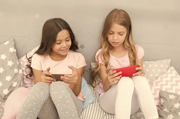 Estamos mais ligados do que nunca. Crianças pequenas usam telefone celular na cama. Comunicação móvel. Comunicações celulares. Tecnologia de comunicação. Comunicação por SMS. Vida moderna — Fotografia de Stock