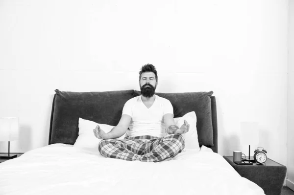 Мужчина пижама сидеть кровать спальня утром медитация, успокоить концепцию — стоковое фото