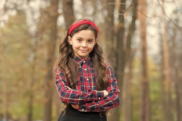 Fashion trend. Accessories. Fancy child nature background. Padded headband. Smiling girl wear knotted headband. Biggest Hair Accessory Trends. Adorable little girl checkered shirt wear red headband