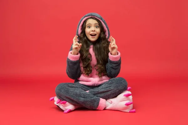 Vidskeplig flicka i påsk kanin pyjamas gör önskan att hålla tummarna för tur, vidskepelse — Stockfoto