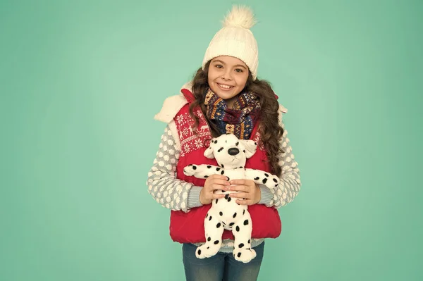 Насолоджуйся зимовими канікулами разом. маленька дівчинка тримає іграшку для собак. дитина любить свого пухнастого цуценя. зимова активність і веселощі. щастя дитинства. модний дитячий бірюзовий фон. дитина щаслива грати з іграшкою — стокове фото