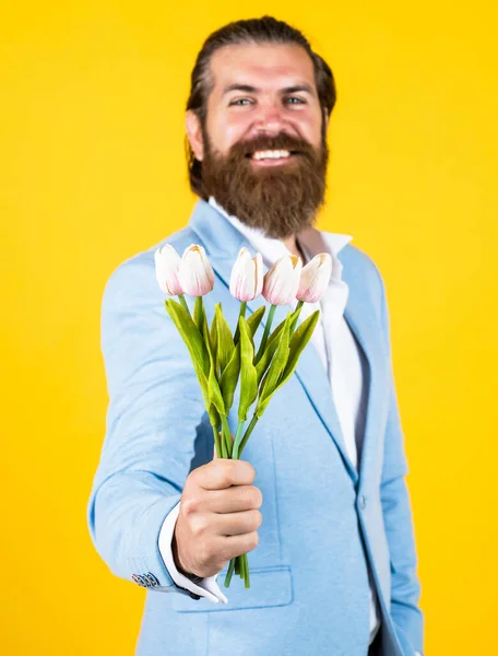 Prends-le. heureux jour des pères. marié marié mature avec bouquet. Un hipster tient des fleurs de tulipes. cadeau pour rendez-vous romantique. homme barbu dans une veste élégante tenir des fleurs. jour de mariage — Photo