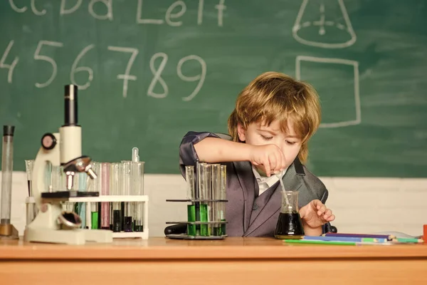 En vetenskapsman som studerar naturvetenskap. En liten pojke på lektionen. Tillbaka till skolan. Vetenskapliga experiment med mikroskop i labbet. Den lille pojken gör vetenskapliga experiment. Biologivetenskap. Kunskapsdag — Stockfoto