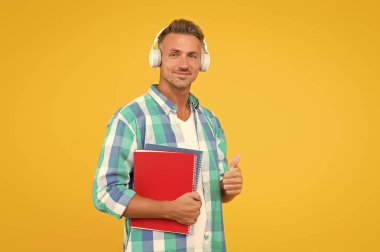 Keşfedilecek en iyi online öğrenme platformları. İnternette konferans dinleyen adam. Yetişkin öğrenci müzik dinler. Adam kulaklık takıyor. Sonsuz öğrenme. Karantina sırasında uzak öğrenim için çevrimiçi kurslar