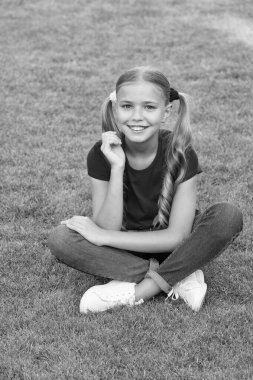 Koru kendini. Mutlu çocuk yeşil çimlere oturur. Çocuk bakımı ve çocuk sağlığı hizmetleri. Cilt bakım ürünleri. Yaz cilt bakımı. Saç bakım kozmetikleri. Saç bakımı. Güzellik salonu. Kendine iyi bak.