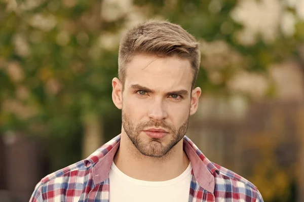Good looking guy. Spring fashion for men. Guy with stylish haircut. Facial care. Charismatic fashion model. Handsome unshaven man outdoors. Man wear checkered shirt. Male beauty and fashion