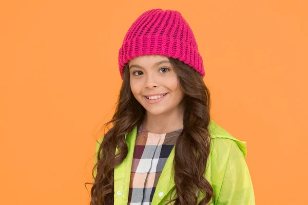 冬の帽子のスタイル。子供の女の子はニット帽を着用。冬のアクセサリーコンセプト。女の子の長い髪の黄色の背景。寒い季節の概念。冬のファッションアクセサリー。暖かい帽子をかぶっている小さな子供。様式ガイド — ストック写真