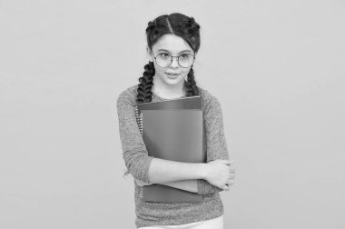 Öğrenim amaçlarınıza ulaşın. Küçük kız kitapları sarı arka planda tutuyor. Küçük çocuk okula geri döndü. Eğitim ve eğitim. Ev eğitimi ve eğitim. Özel ders. Okul dersleri için çalışma materyali