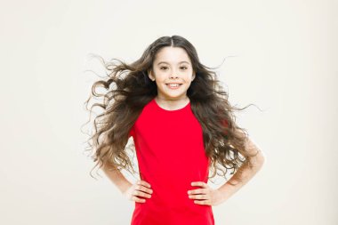 Çok güzel hissediyorum. Moda kızı. Sarı arka planda şirin bir manken. Moda görünümlü küçük bir çocuk. Moda tarzında uzun kıvırcık saçlı sevimli bir çocuk.