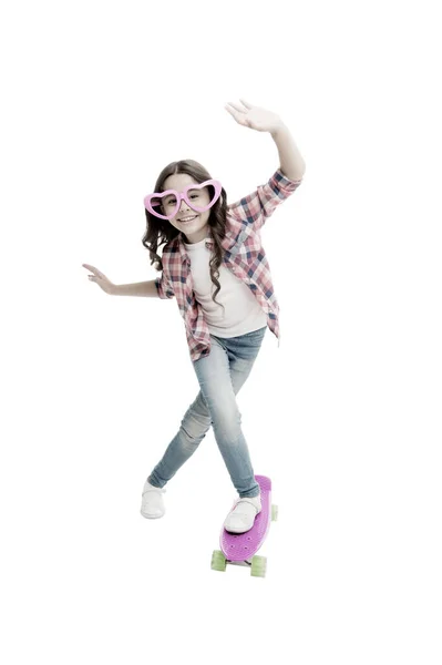 楽しみましょう。ペニーボードで楽しんでいる子供。子供の笑顔の顔はスケートボードスタンド。ペニーボード女の子のためのかわいいスケートボード。乗るぞ。女の子はペニーボードの白い背景に乗る。夏休み — ストック写真