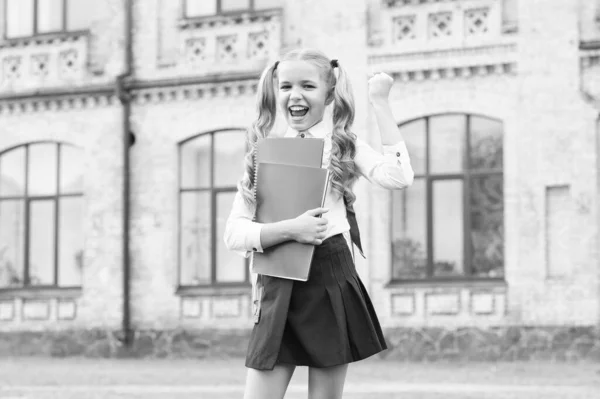 Дитяче майбутнє. концепція освіти та читання. розвиток уяви. мила дівчина тримає блокнот. щаслива дівчина дошкільного віку на шкільному подвір'ї. повернутися до школи. працьовита дитина носить рюкзак — стокове фото