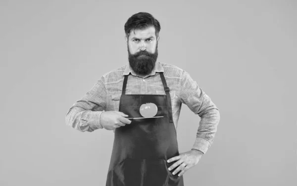 A sério sobre comida. Homem barbudo segura o tomate na faca. Cozinhar comida vegetariana. Legumes orgânicos. Alimentação saudável. Nutrição natural. Dieta e dieta — Fotografia de Stock