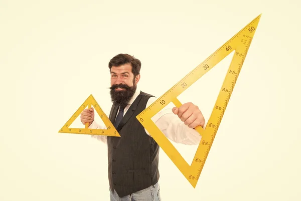 Τι είναι το τρίγωνο. Ο γενειοφόρος κρατάει τα τρίγωνα απομονωμένα στο λευκό. Ο δάσκαλος χαμογελάει με γεωμετρικά τρίγωνα. Μάθημα Γεωμετρίας. Μαθηματικά. Τρίγωνα με τρεις πλευρές και τρεις γωνίες — Φωτογραφία Αρχείου