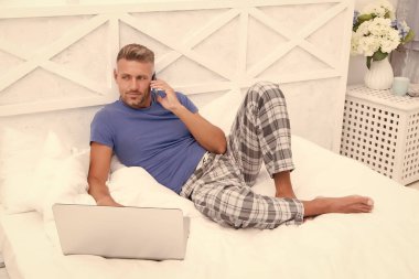 Yemek sipariş et. Çevrimiçi servis. Uzaktan çalışma konsepti. Sosyal ağlar. Çevrimiçi dünya. İnternette sörf yapan adam. Dijital pazarlama. Uzaktan erişim. Olgun erkek pijama işçisi evde dinleniyor.