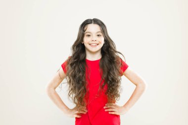 Mükemmel bir saç stili. Sevimli gülüşü ve moda saç stili olan küçük bir çocuk. Sarı arka planda dalgalı saçlı mutlu çocuk. Uzun dalgalı saç stiliyle gülümseyen sevimli küçük kız. Saç stili eğilimleri