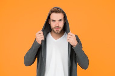 Rahat hissediyorum. Genç adam tarzı sarı arka plan. Sıradan tarzda yakışıklı bir adam. Genç manken kapüşonlu giyiyor. Genç erkekler için moda trendleri. Genç ve çağdaş