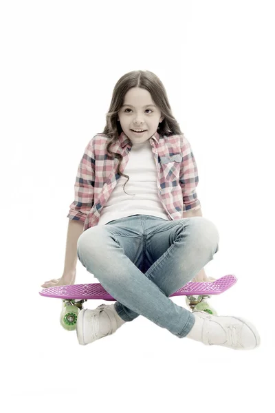 Assieds-toi. La gamine détendue est assise sur un penny board. Apprendre à monter penny board. Un passe-temps adolescent moderne. Fille visage heureux assis sur le tableau penny fond blanc. Initialement conçu comme skateboard pour filles — Photo