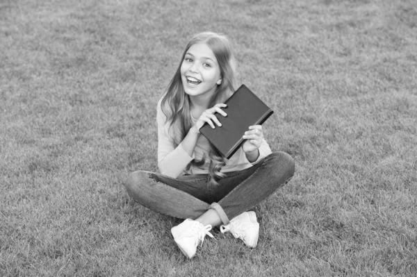 Chica leyendo libro al aire libre césped verde fondo, concepto de hobby intelectual — Foto de Stock