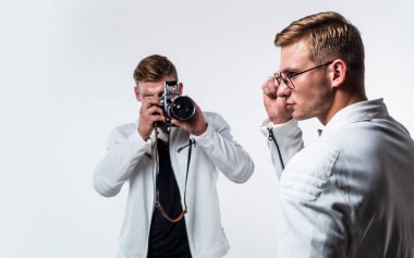 Benzer görünüşlü genç ikiz kardeş fotoğrafçı. Retro kamerayla fotoğraf çek.