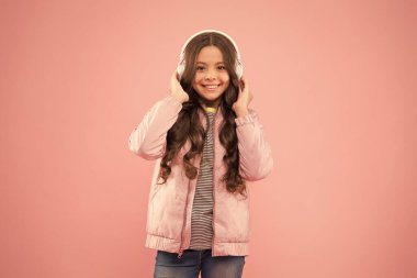 Çok modaya uygun görünüyorsun. Kulaklıkla çalan eğlenceli şarkı. Karaoke ve eğlence. Bir şarkıya katılıyorum. Küçük kız pembe arka planda şarkı söylüyor. Küçük çocuk şarkıda vokal yapıyor. Duygusal şarkıcı.